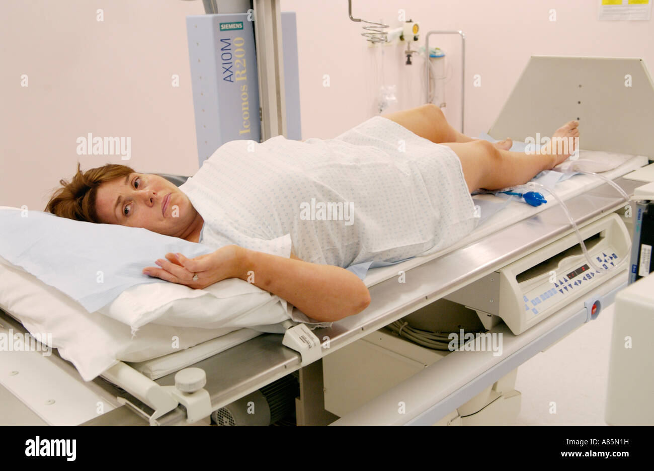 Donna con enema del bario sulla tavola di Siemens Medical Solutions Axiom Iconos R200 fluoroscopia l'unità di imaging ospedale privato REGNO UNITO Foto Stock