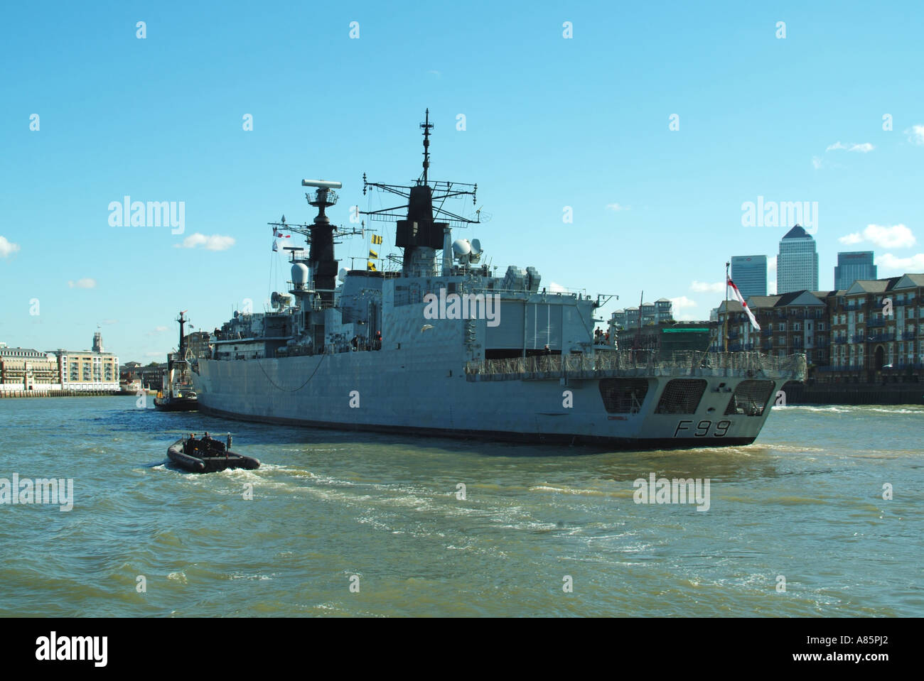 Il fiume Tamigi ad alta marea Frigate F99 Cornwall essendo assistita da rimorchiatori durante le manovre di rotazione dopo la partenza da pool di Londra Foto Stock