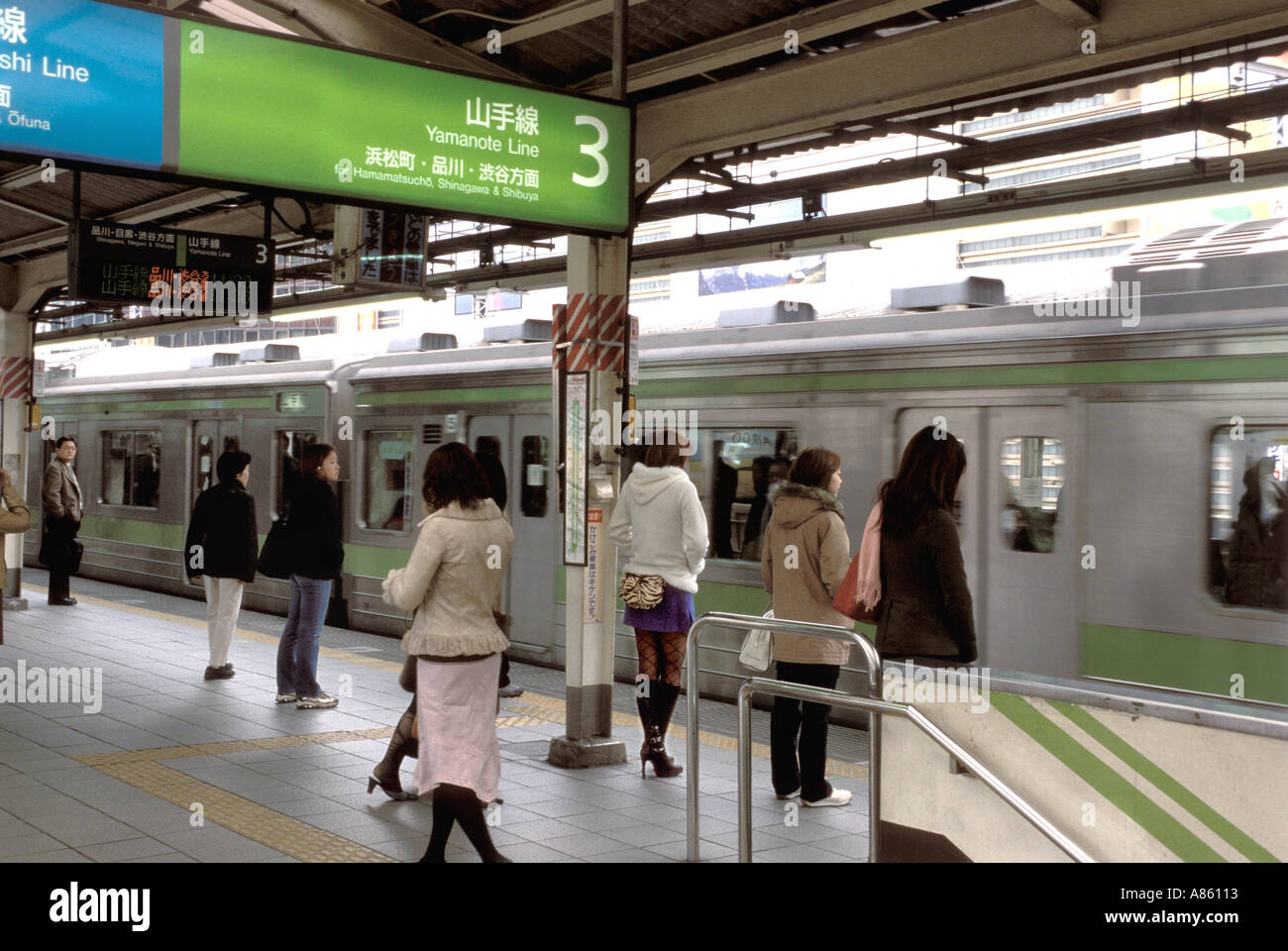 Persone in attesa al bordo della Yamanote linea loop treno che circonda l'area metropolitana di Tokyo City Foto Stock