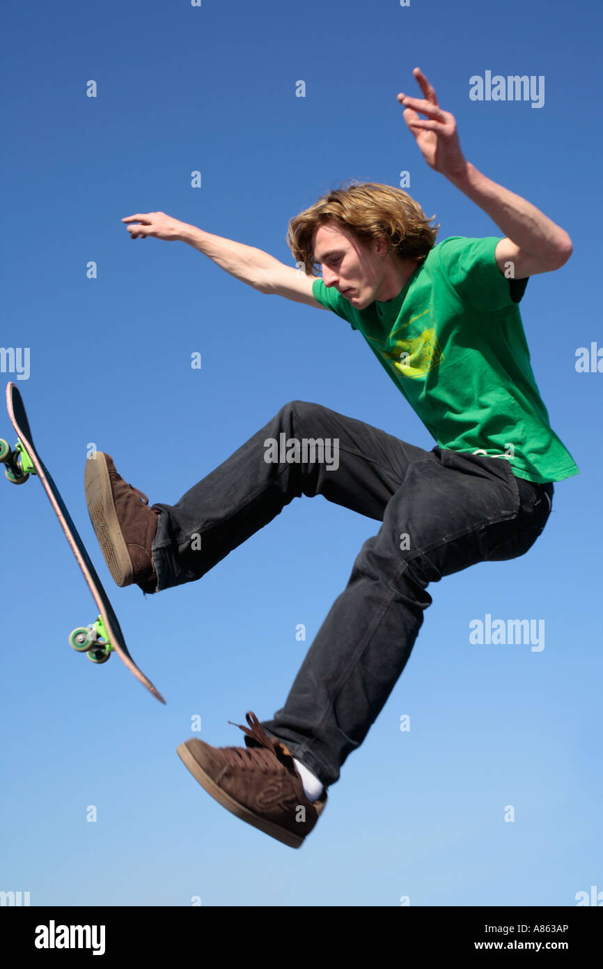 Un giovane pattinatore salta con il suo skateboard Foto Stock