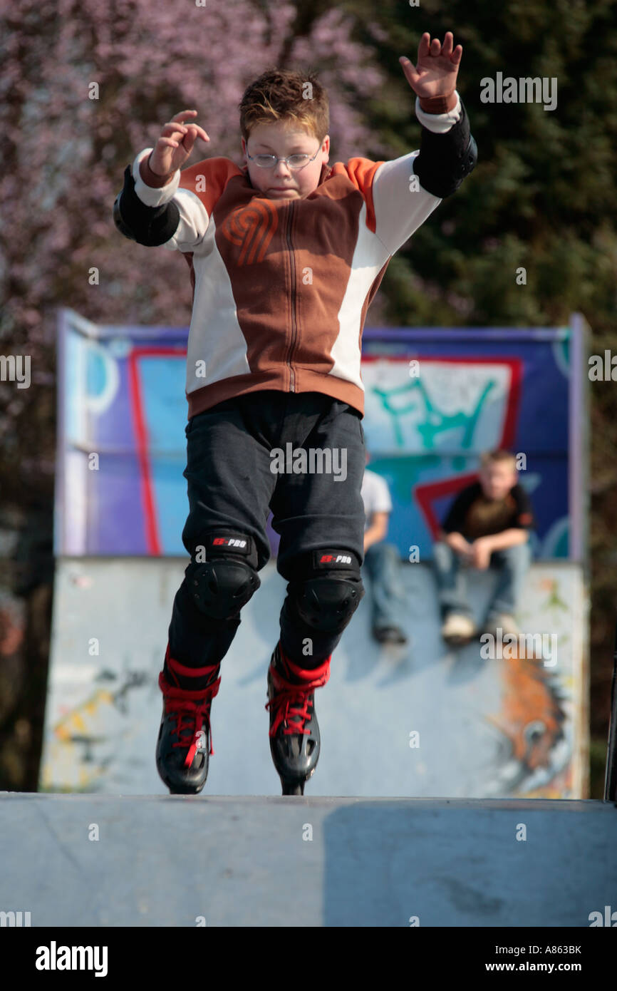 Un giovane skater è la pratica di salto con i suoi pattini Foto Stock