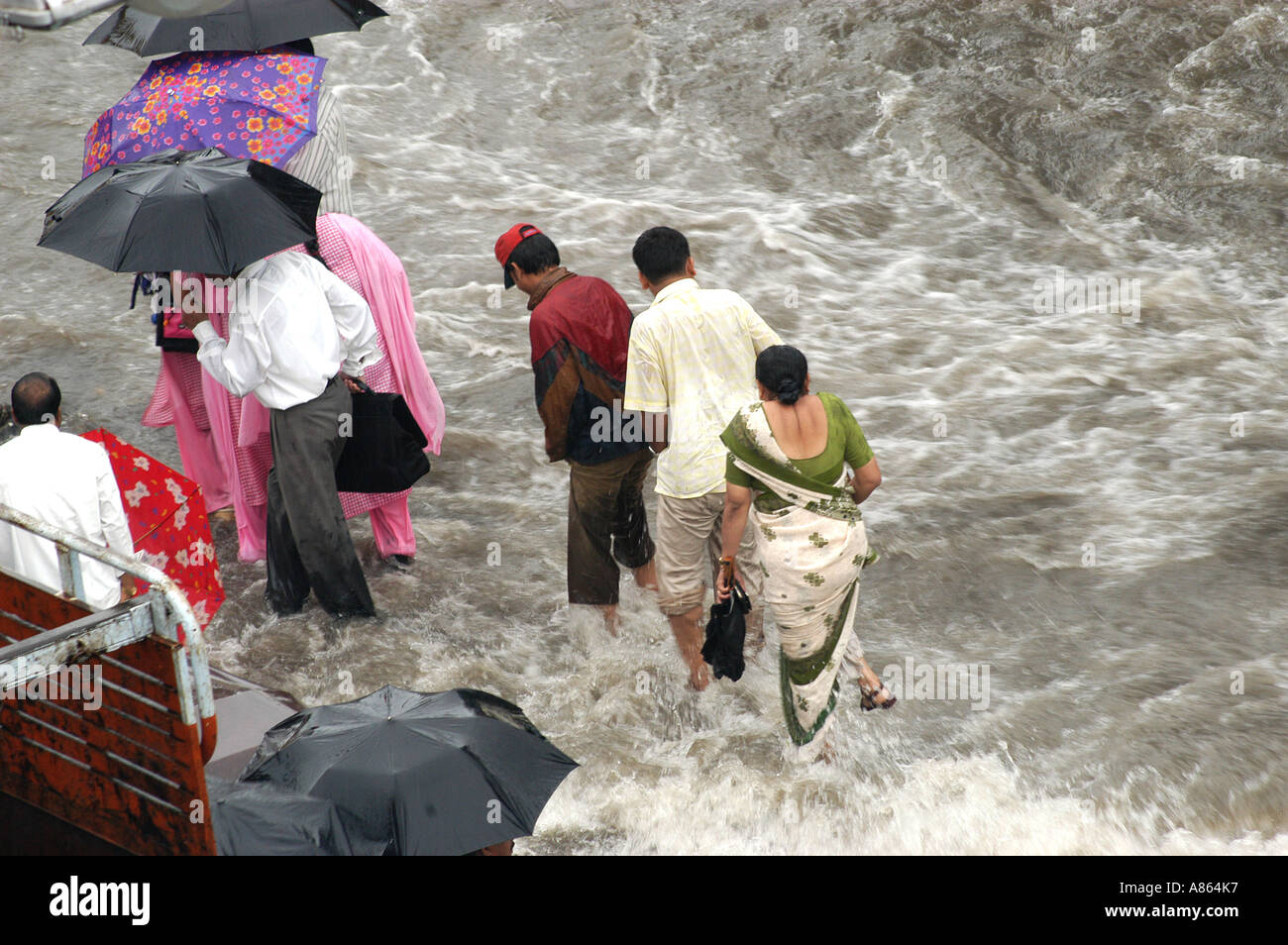 Popolo Indiano a camminare sulle strade allagate con piogge monsoniche acqua a Bombay città di Mumbai India Foto Stock
