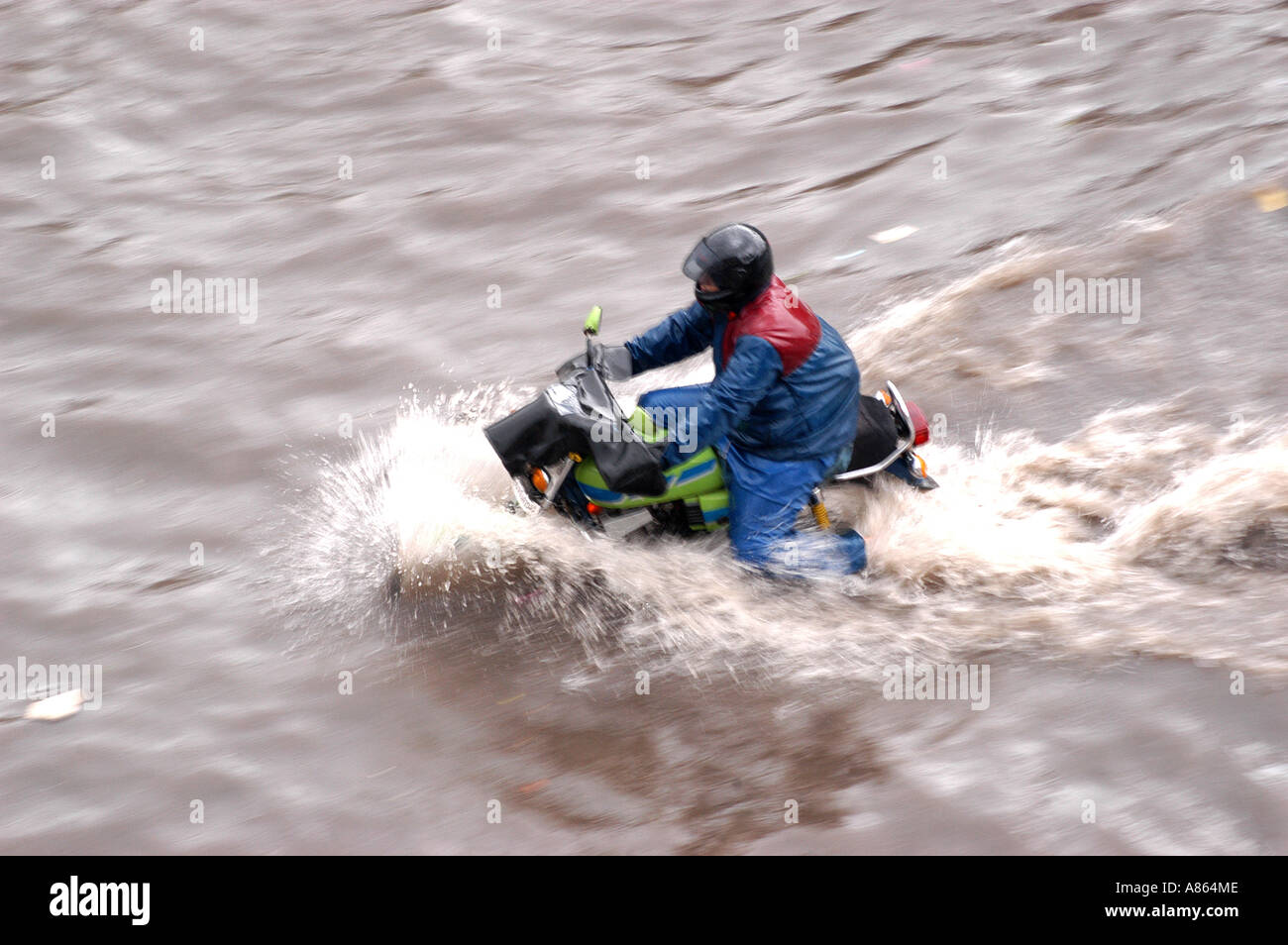 Uomo in bici guida attraverso strade inondate su record pioggia pesante giorno a Bombay città di Mumbai India Foto Stock