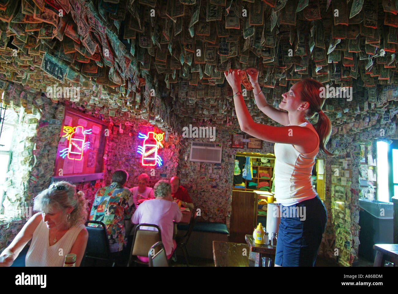 Una donna mette un dollaro sul soffitto del No Name Pub sulla Big Pine Key Foto Stock