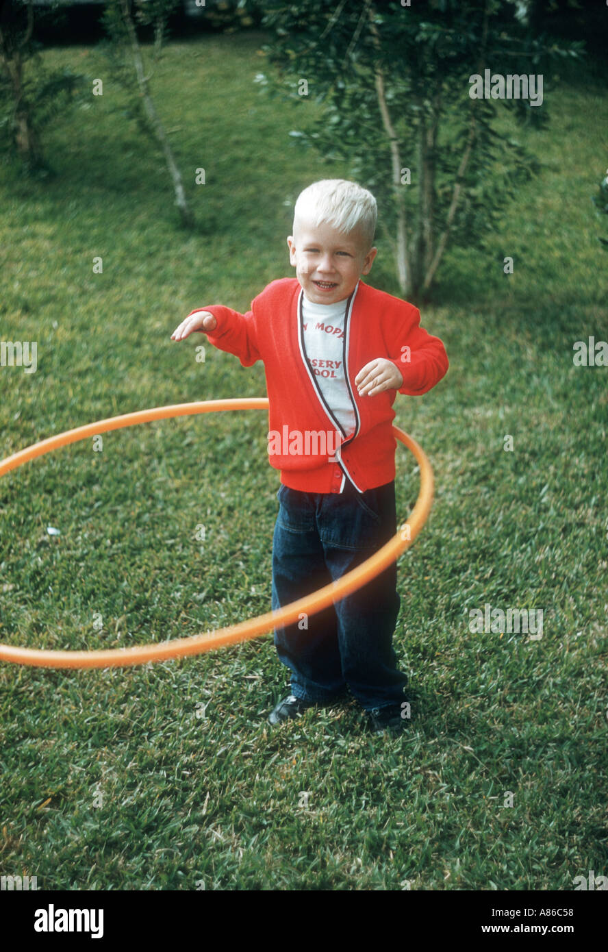 Piccolo ragazzo giocando con hula hoop Foto Stock