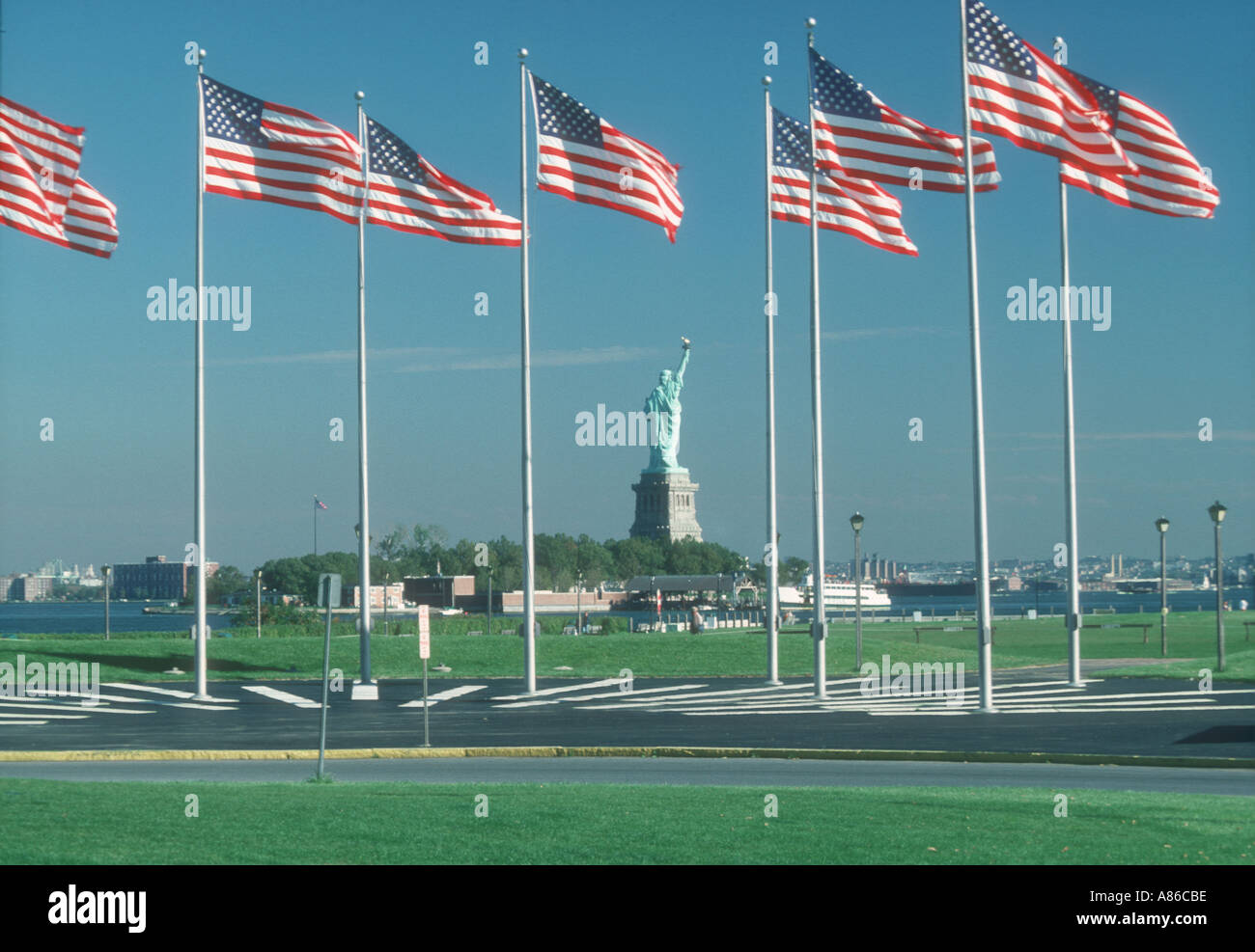 Statua della Libertà in prossimità di una linea di bandierine americane nel porto di New York Foto Stock