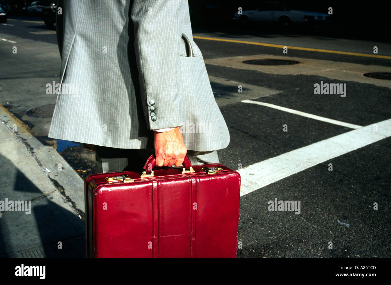 Un uomo di affari e la sua valigetta sul modo di lavorare Foto Stock