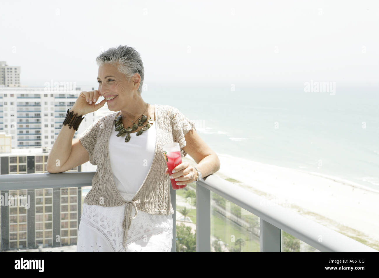 Donna matura sorridente su una terrazza Foto Stock