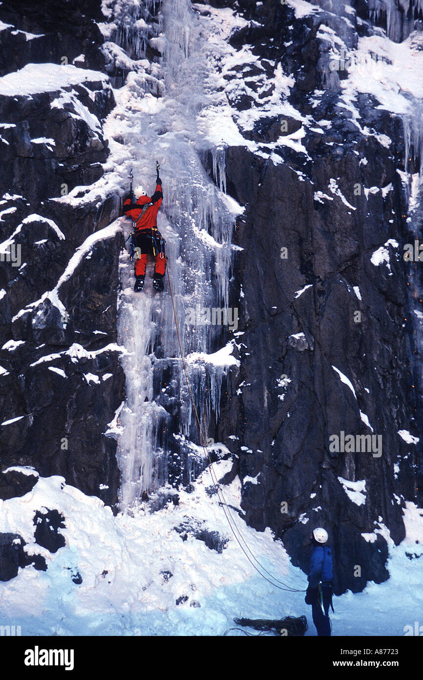 Gli alpinisti sul ricoperto di ghiaccio cascata sul versante di una montagna che indossa ingranaggio di sicurezza Foto Stock