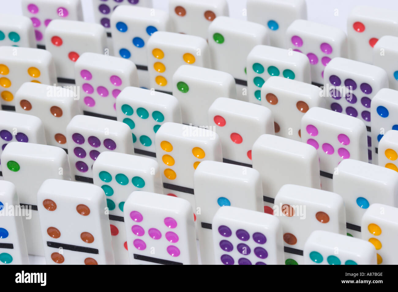 File uniformi di tessere bianche con puntini colorati in piedi sull'estremità Foto Stock