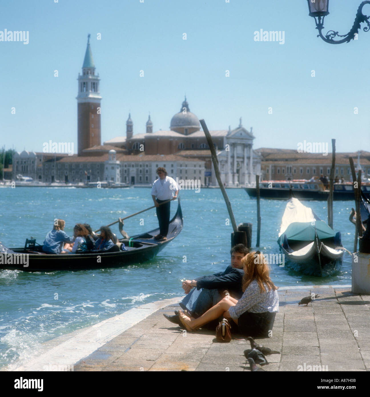 Soft focus colpo di una giovane coppia di gondoliere e l' Isola di San Giorgio Maggiore dietro, Grand Canal, Venezia, Italia Foto Stock