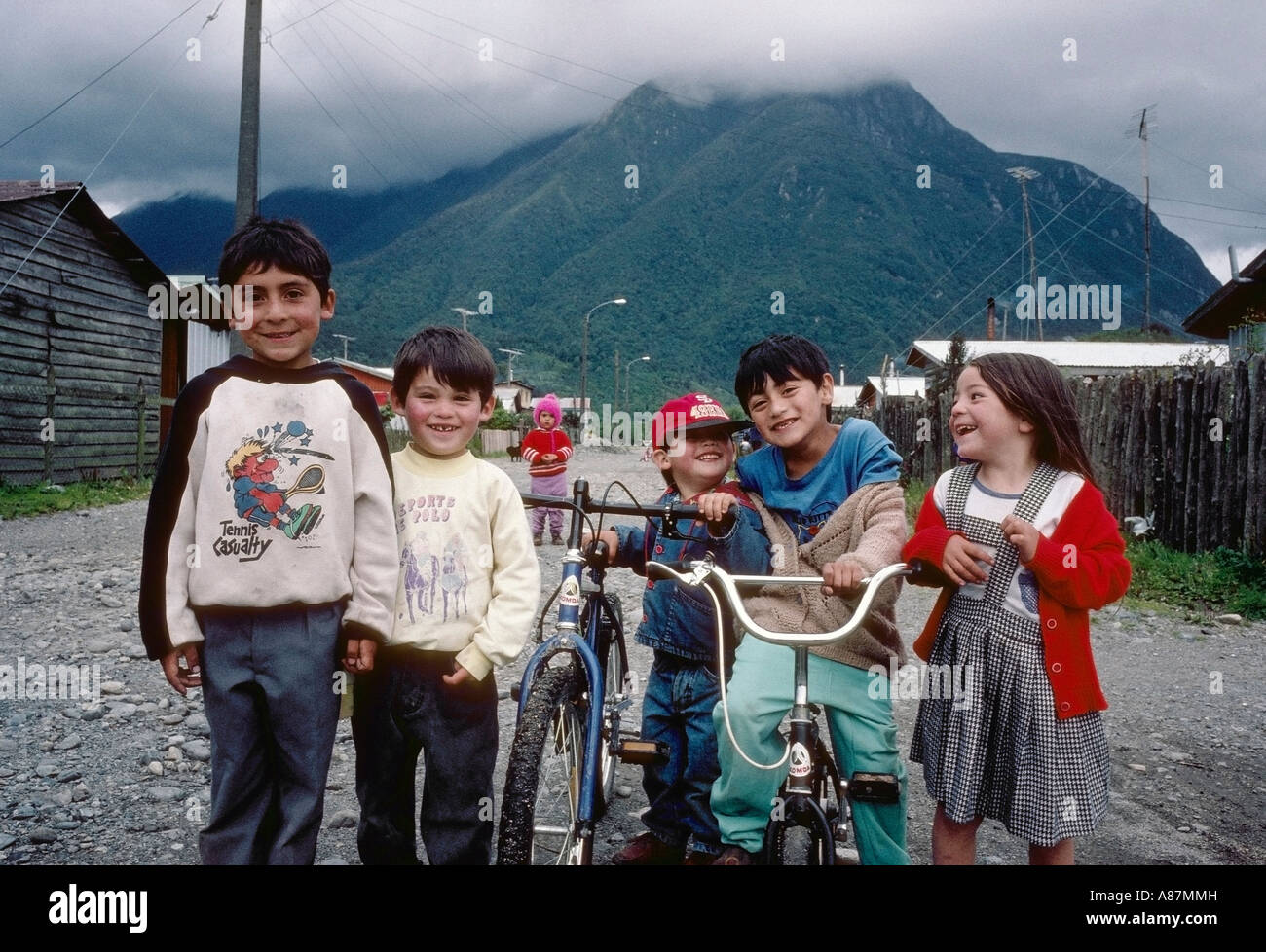 Ritratto di un gruppo di bambini cileni con le biciclette su una strada di  Chaitén Patagonia Cilena con la montagna in background Foto stock - Alamy