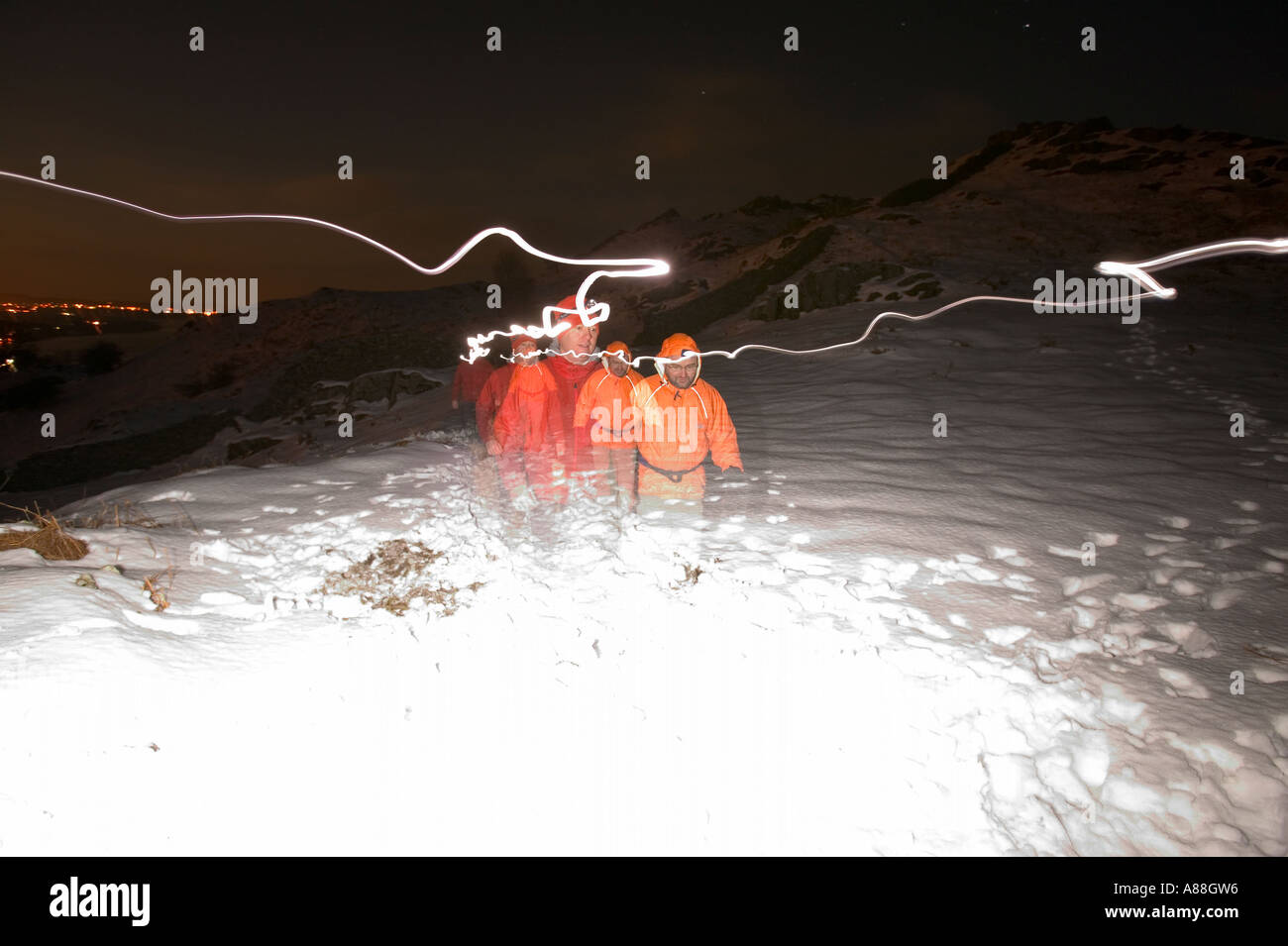 Luna piena sopra Ambleside in inverno la neve con gli alpinisti ascendere alla luce delle fiaccole, Lake District, Cumbria, Regno Unito Foto Stock