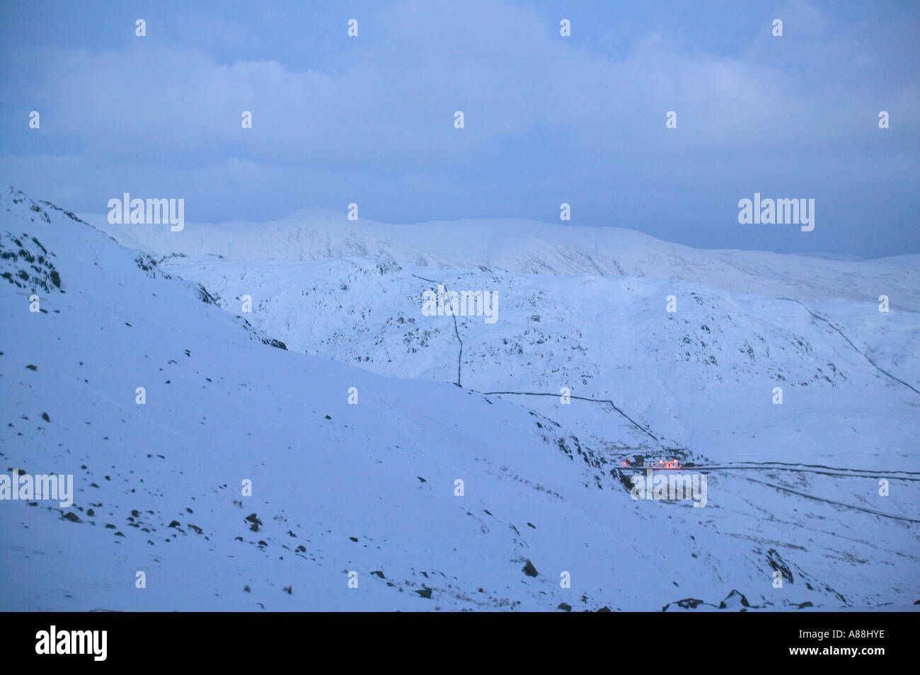 Il kirkstone Pass Inn sotto Red ghiaioni, in inverno la neve, Lake District, Cumbria Regno Unito, al crepuscolo Foto Stock