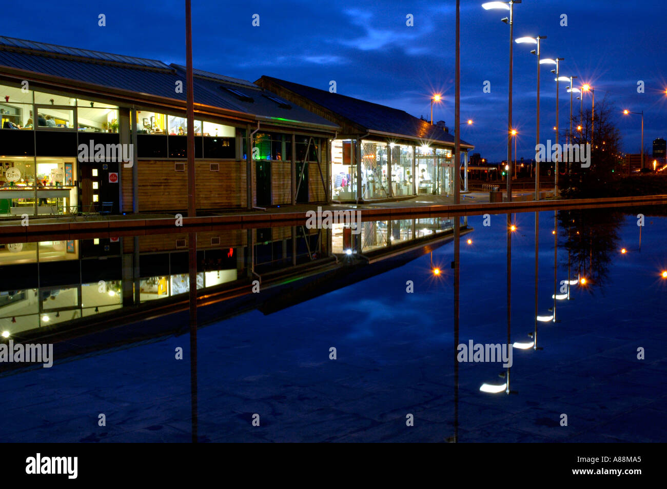 Oriel Gallery Shop si riflette in una piscina con fontana di notte la baia di Cardiff Galles del Sud Foto Stock