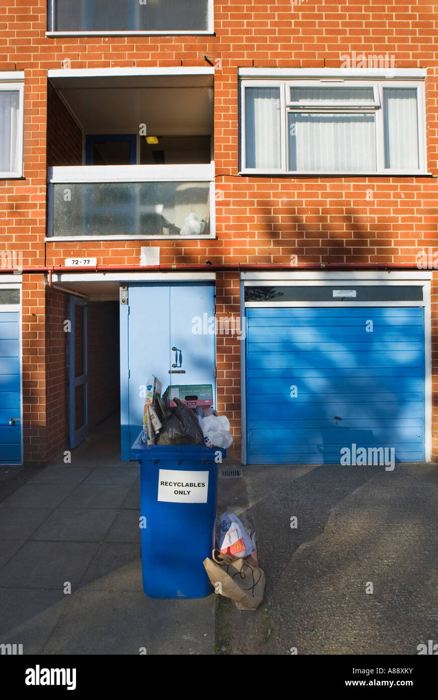 Riciclo completo bin al di fuori di un blocco di appartamenti. Harlow Town, Regno Unito Foto Stock