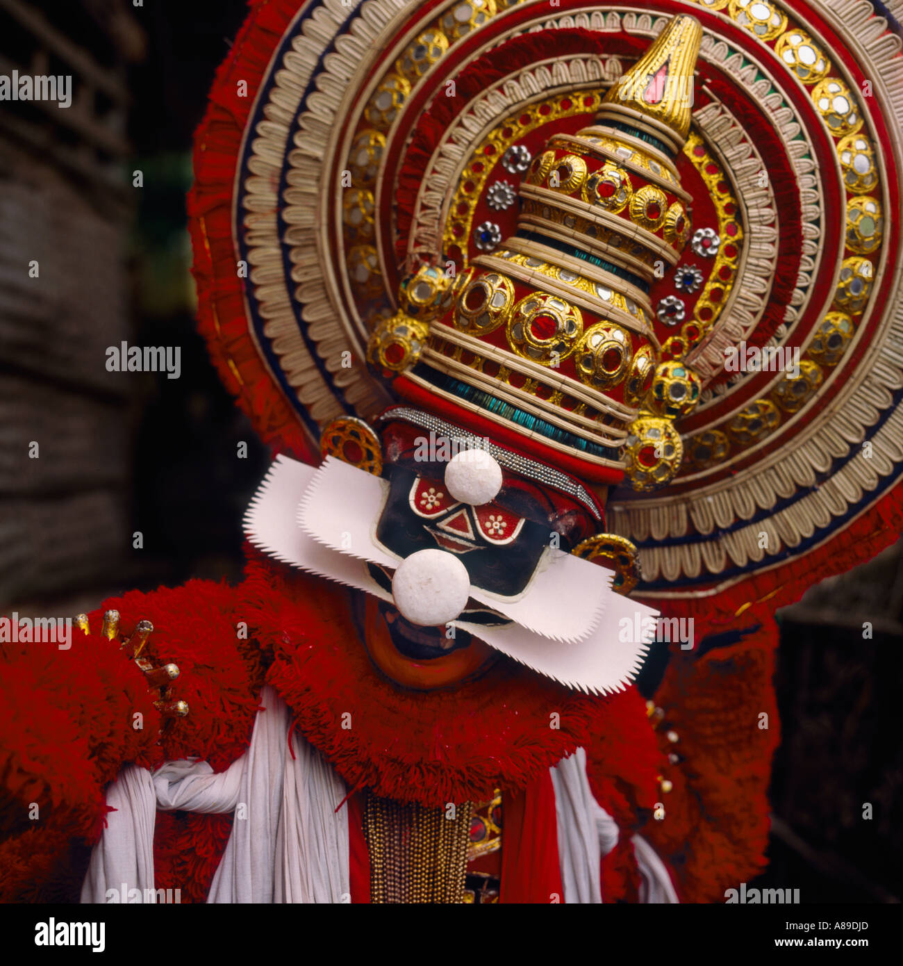 Ritratto di un danzatore Kathakali con la sua torre spettacolare gioiello incrostato testa-vestito di eseguire in Kerala Cochin India del Sud Foto Stock