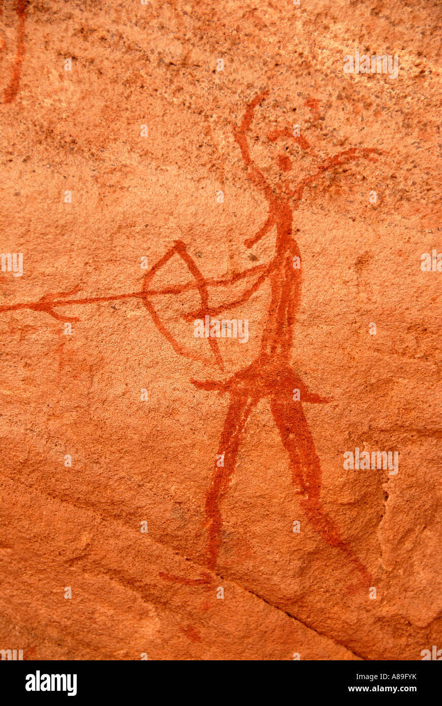 Roccia del neolitico di disegno di un essere umano con arco e frecce e una testa di animali Acacus Libia Foto Stock