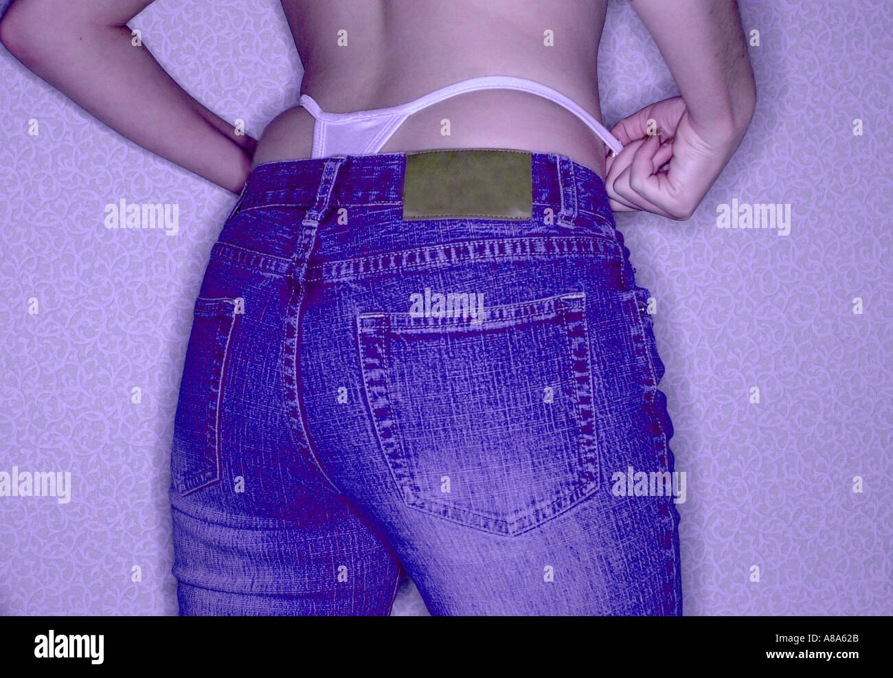 Donna in jeans con mutandine tanga che mostra i pantaloni di cui sopra Foto  stock - Alamy