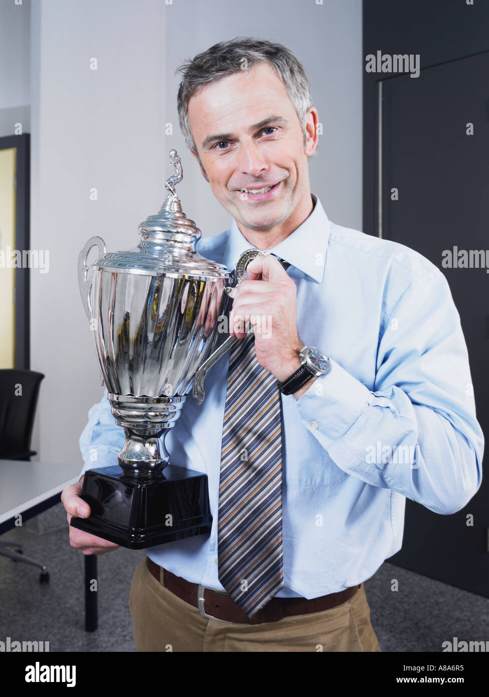 Imprenditore tenendo un trofeo Foto Stock