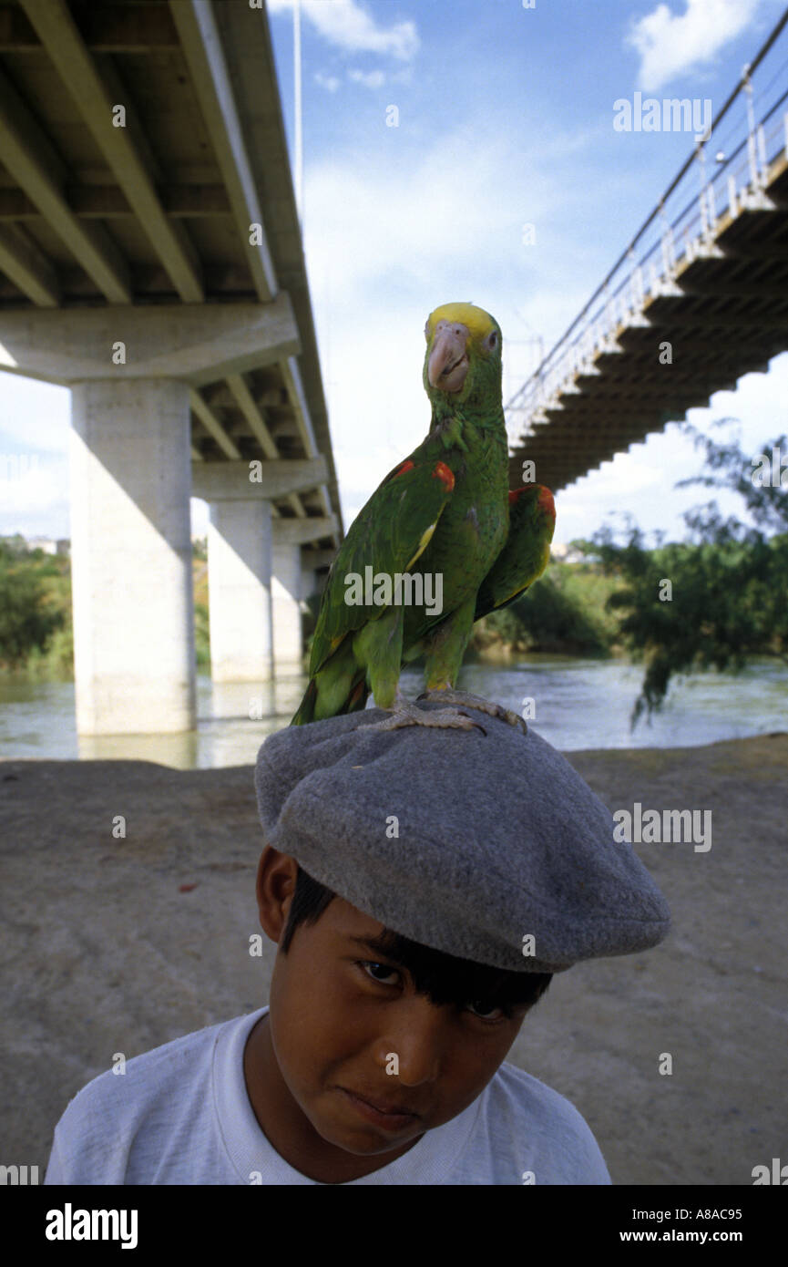 Ragazzo con illegale con testa gialla parrot in Ciudad Acuna Coahuila MESSICO sulle sponde del Rio Grande Rio Bravo River Foto Stock