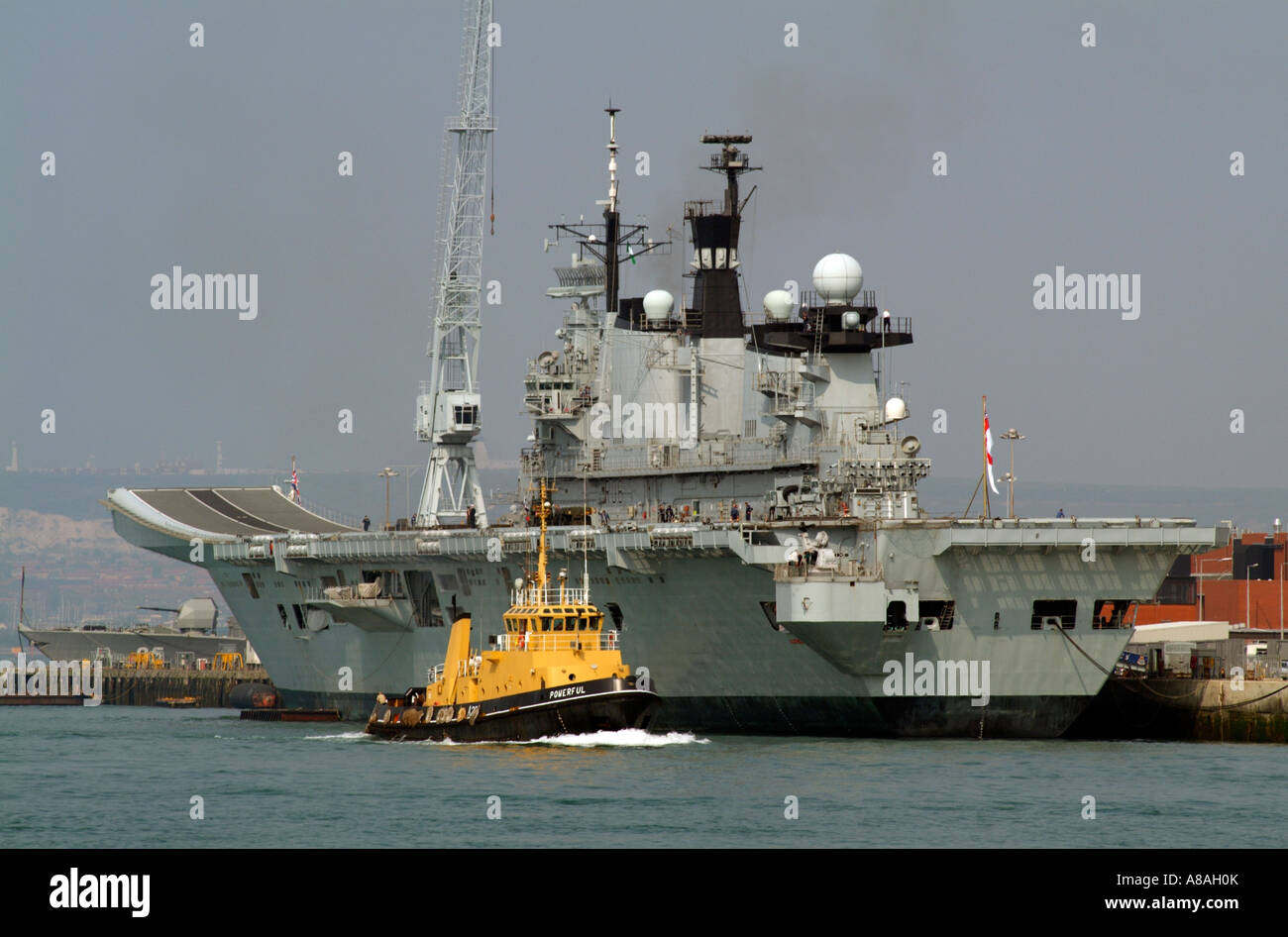 SERCO Denholm azionato nave rimorchiatore potente in corso e la Royal Navy portaerei HMS illustre Portsmouth Regno Unito Foto Stock