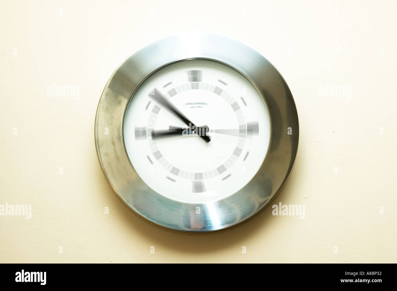 Argento orologio analogico sulla parete con sfondo bianco Foto Stock