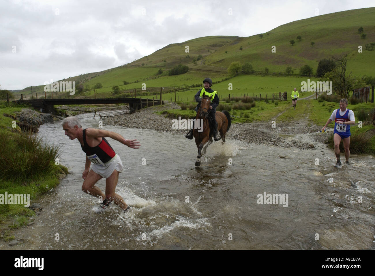 Uomo annuale v corsa di cavalli a Llanwrtyd Wells il Galles Centrale attraversando la Ford Abergwesyn Powys Mid Wales UK Foto Stock