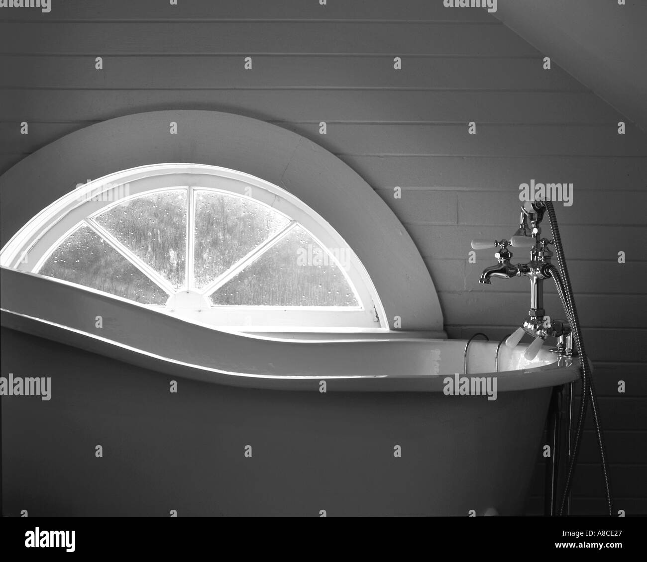 Antica vasca da bagno dalla luce della finestra Foto Stock