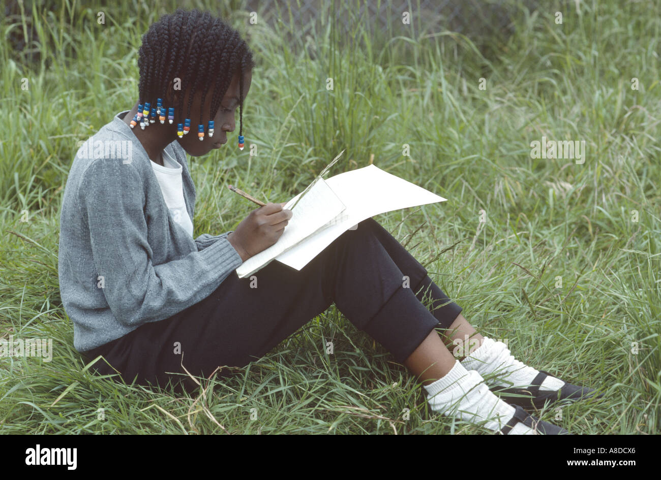 Geografia primaria scuola scampagnata con la giovane ragazza nera scrivere note Foto Stock