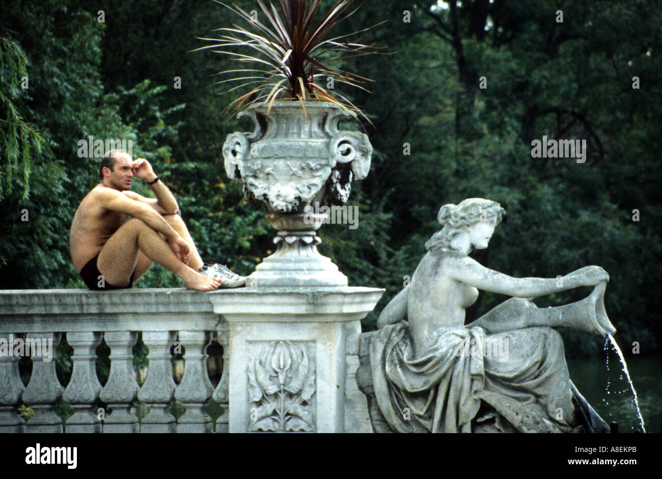 Sunbather maschio colpisce matching posano con statua, Regents Park, Londra Foto Stock