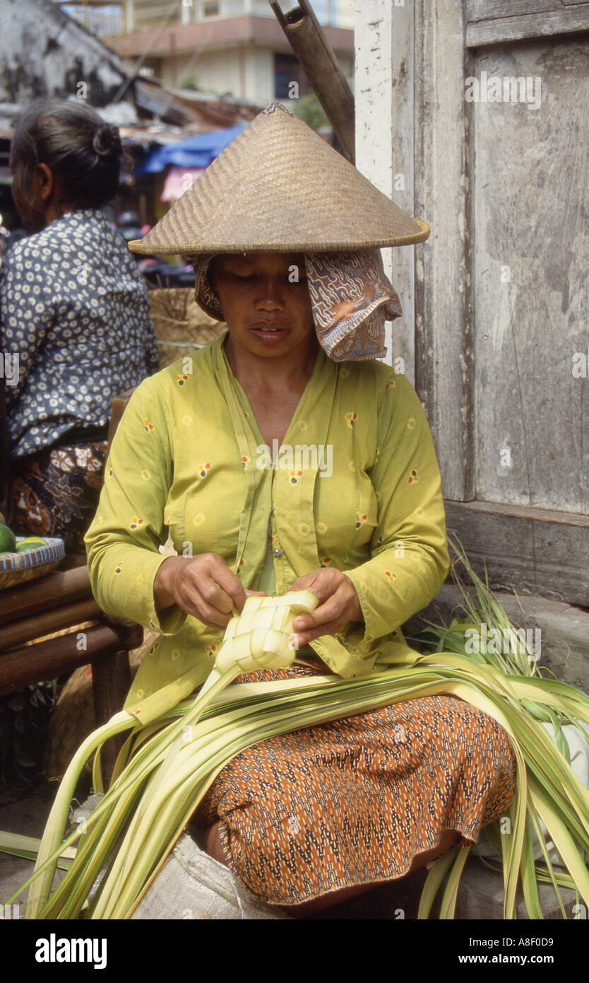 Indonesia Java donna giavanese rendendo ketupat da foglie di noce di cocco Foto Stock