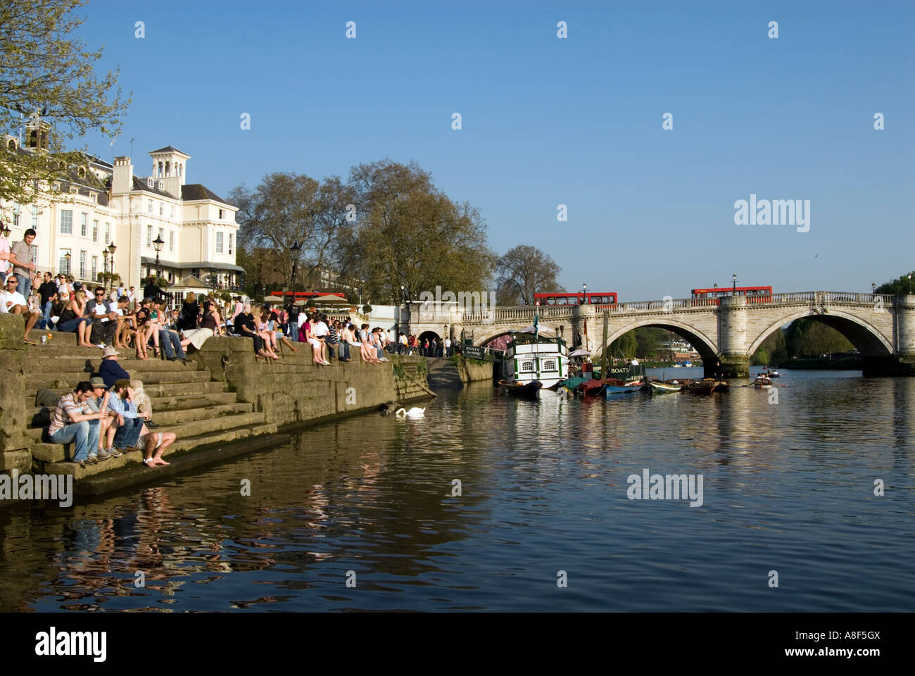 Persone rilassante sulla riva del fiume Tamigi accanto a Richmond Bridge, London, England, Regno Unito Foto Stock