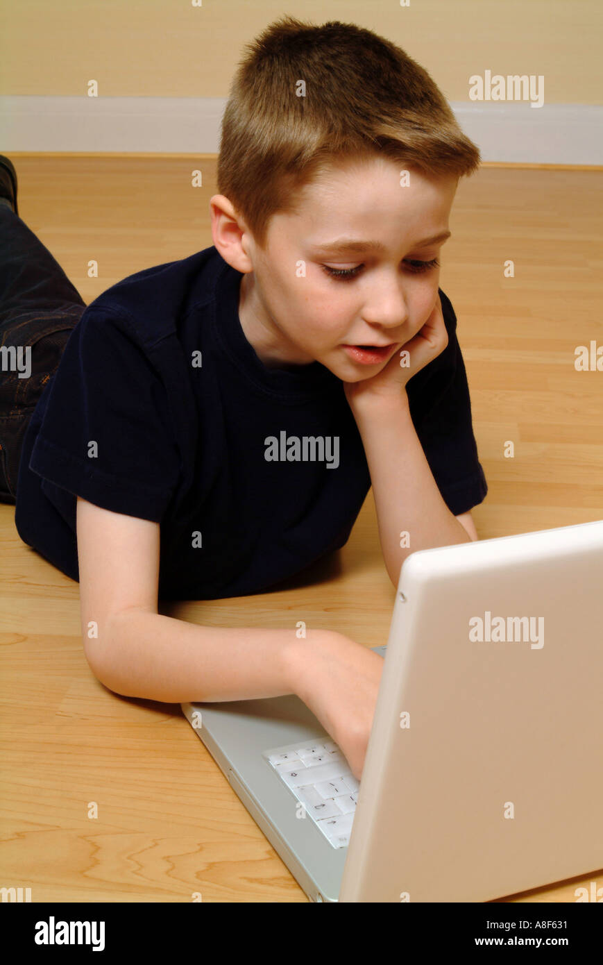 8 anno vecchio ragazzo con un computer portatile Foto Stock