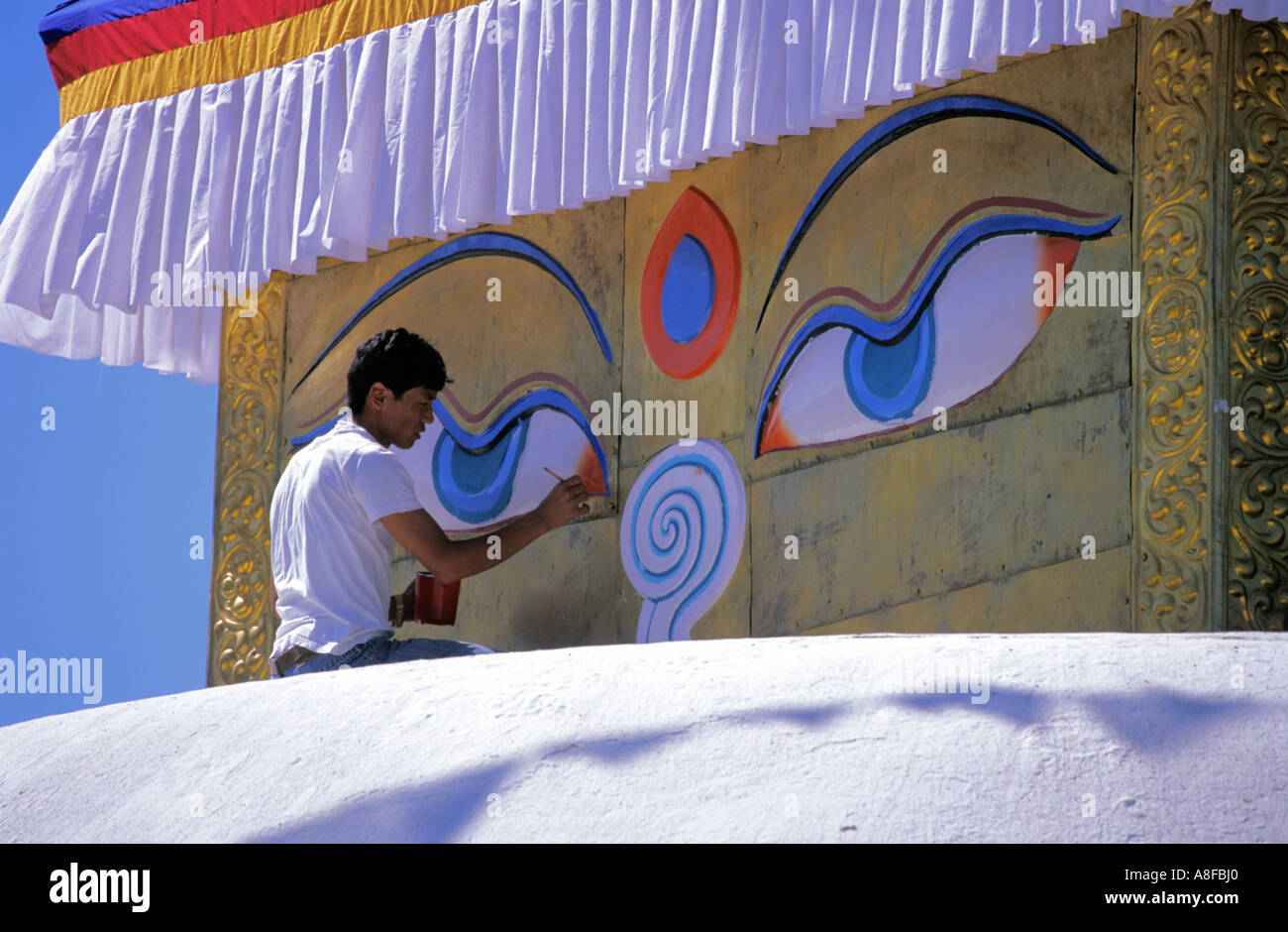 Il nepalese uomo furbishes fino la pittura tradizionale su Charumati stupa di Kathmandu in Nepal città Foto Stock