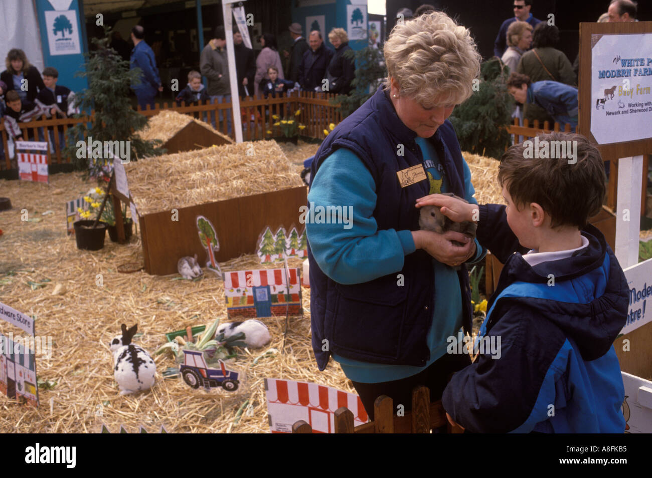 Un membro del personale giovane bambino tendendo un coniglio a conigli mostra nel Nottinghamshire county mostrano in Newark degli anni novanta anni novanta HOMER SYKES Foto Stock