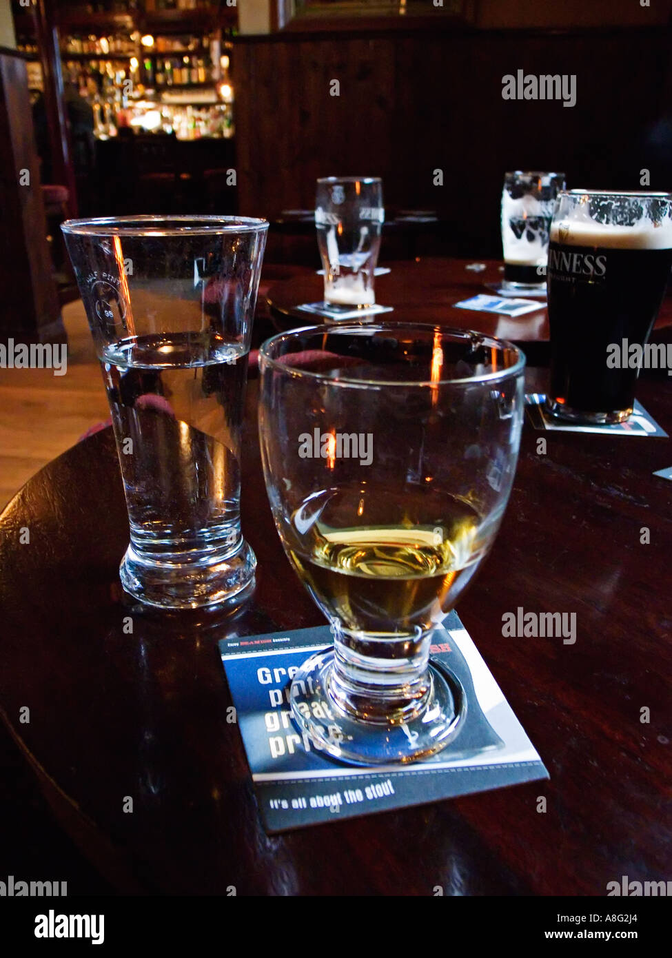 Un bicchiere di whiskey / whisky con altre bevande alcoliche su una tabella pub in Irlanda Foto Stock
