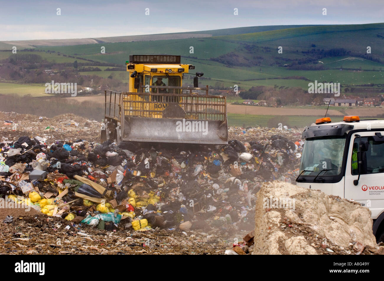 Un luogo di discarica occupato in azione con carrelli per la polvere rifiuti camion e bulldozer. Beddingham, sud-est del Regno Unito. Foto Stock