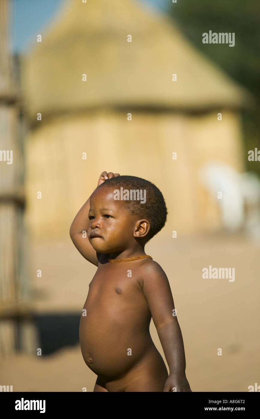 Un giovane Botswanan bambino con un rondavel home in background Foto Stock