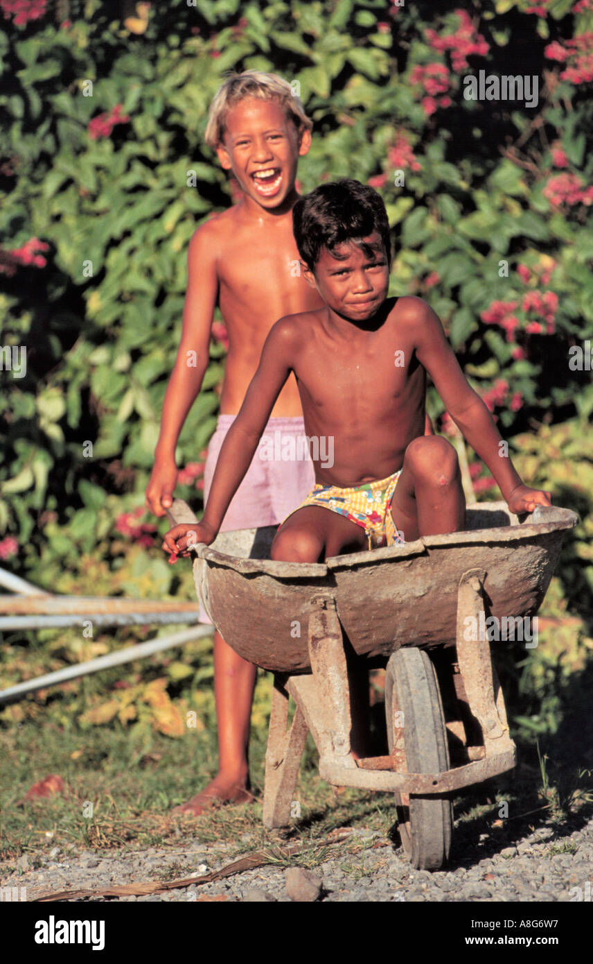 Ragazzi giocare con ruote-Barrow, Bora-Bora, Tahitii, Tahiti Foto Stock