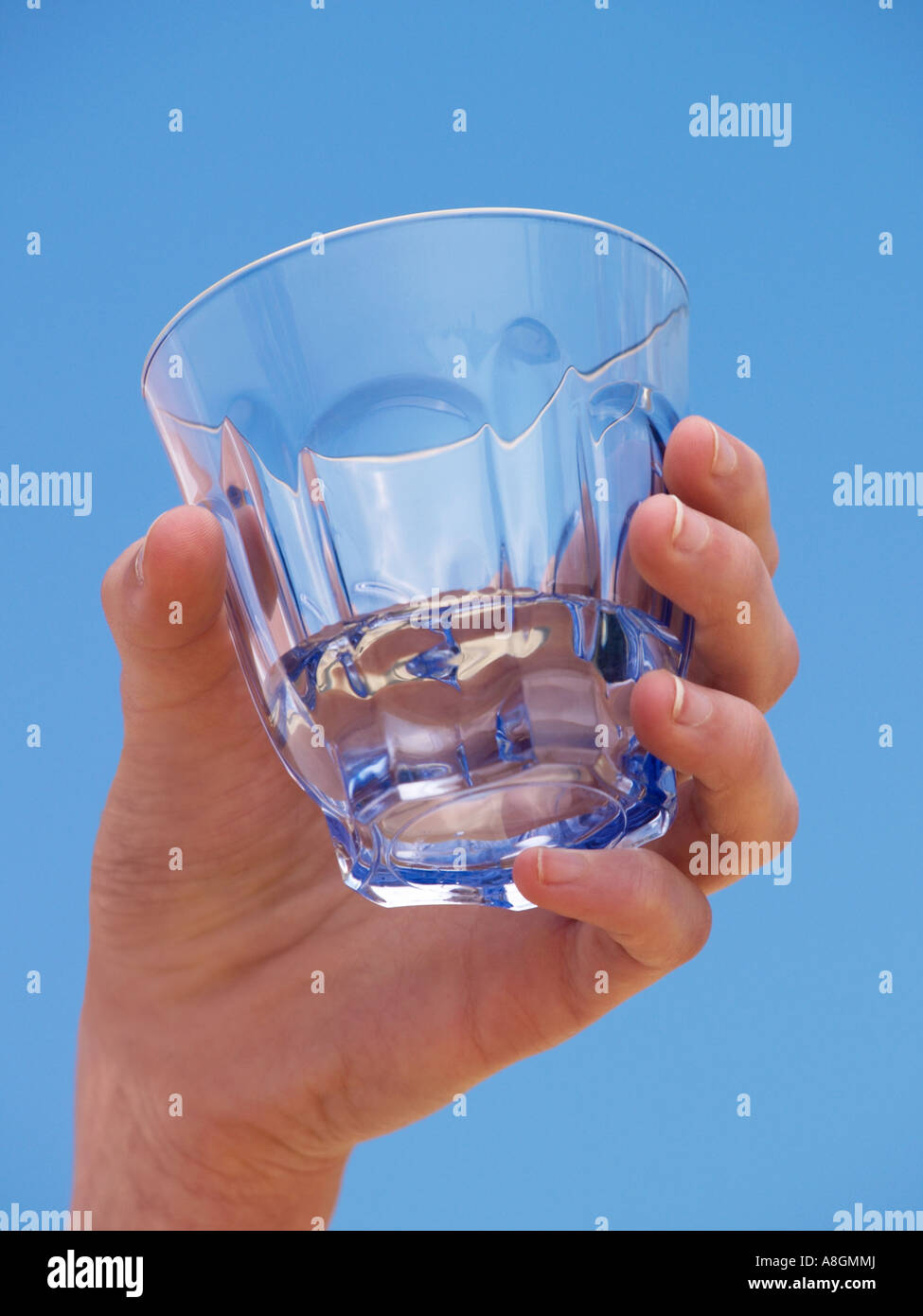 Femmina tenuta a mano in vetro trasparente di acqua minerale contro il cielo blu rinfrescante fresca fresca pulita Foto Stock