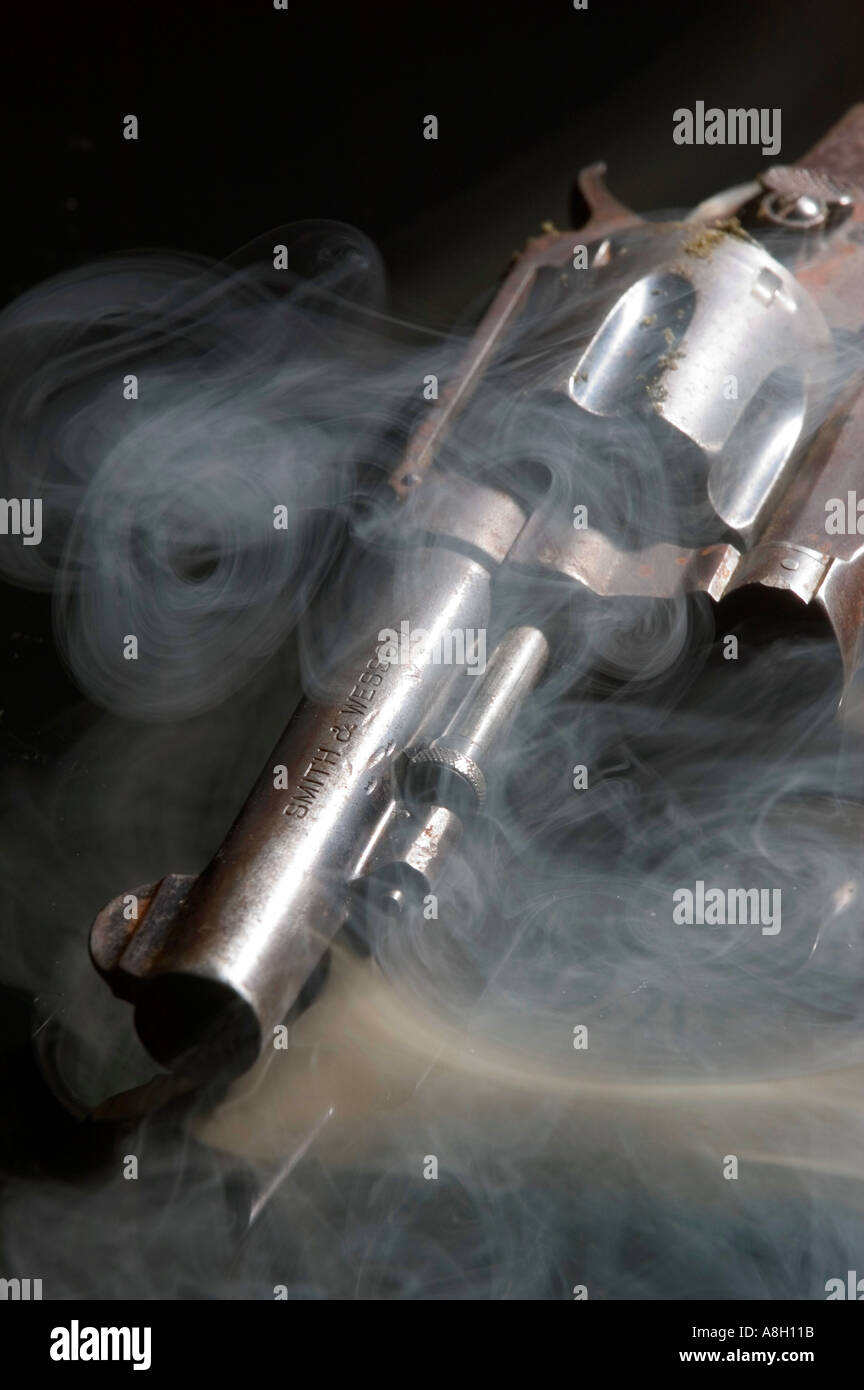 Arrugginita Smith Wesson 38 calibro pistola revolver con fumo riflettente su sfondo nero studio still life Foto Stock