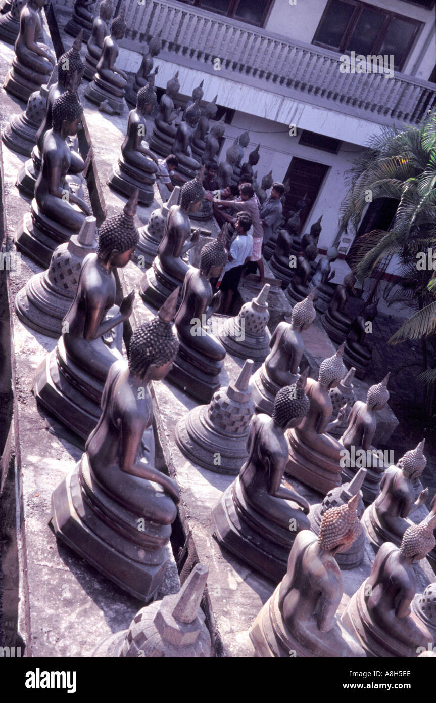 Le immagini del Buddha essendo rivestiti fino al tempio di Gangaramaya complesso in Colombo Sri Lanka Foto Stock