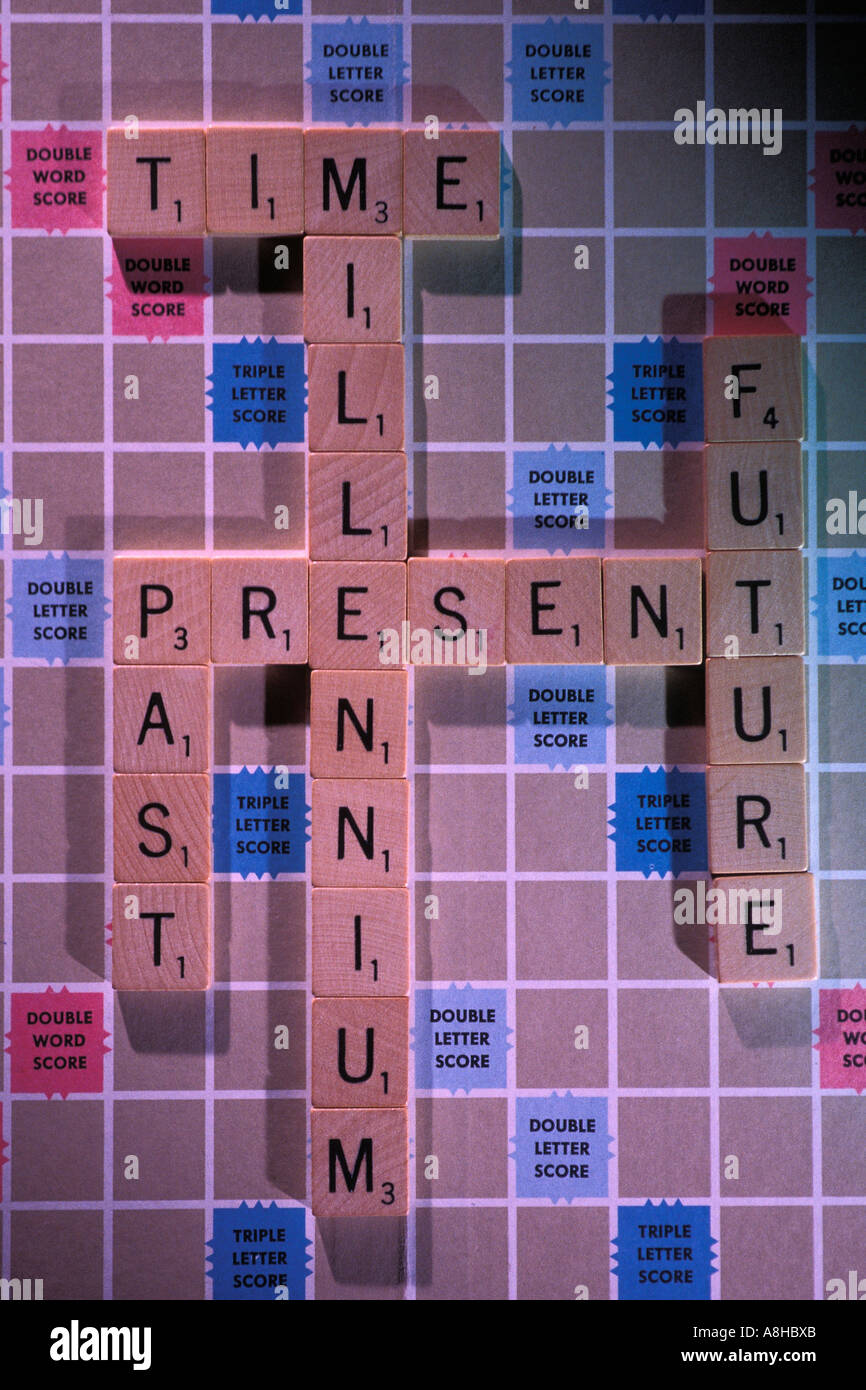 Le parole Passato Presente Futuro millennio e il tempo enunciato con lettere di scrabble su un gioco SCRABBLE board Foto Stock