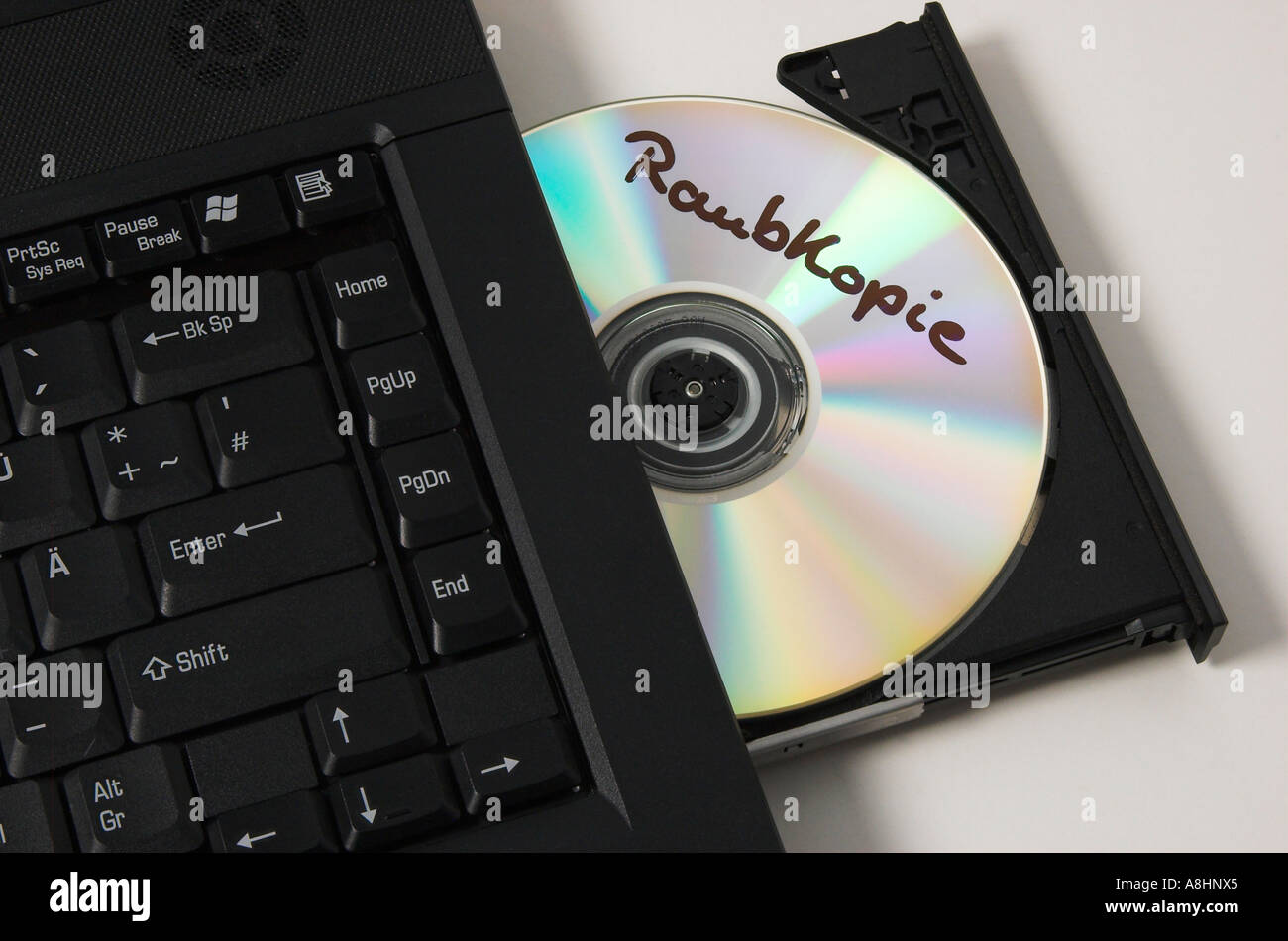CD ROM con l'etichetta "Raubkopie' giacente in unità CD di un computer notebook Foto Stock