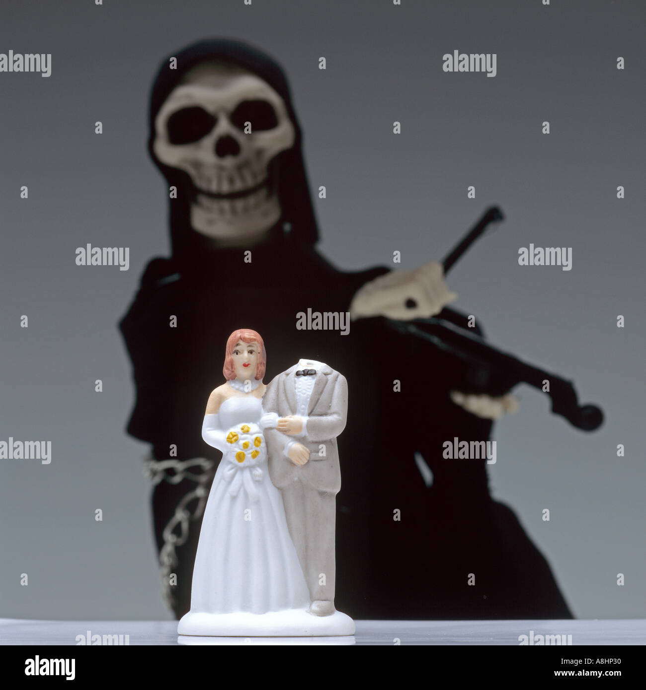 Sposa e lo sposo headless figurine nella parte anteriore del Grim Reaper suonare il violino Foto Stock