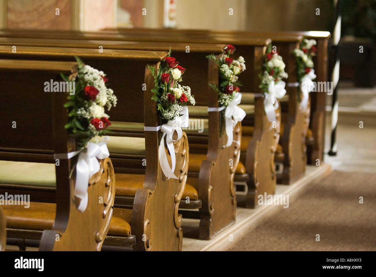 Addobbi floreali per un matrimonio sui banchi di preghiera in una chiesa  Foto stock - Alamy