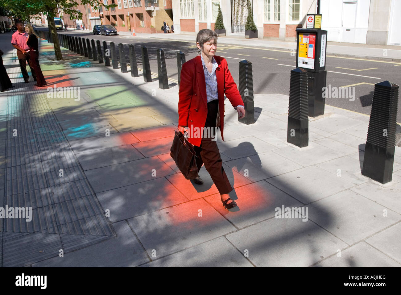 Una donna cammina anche se qualche luce rossa al di fuori della Home Office di Londra Foto Stock