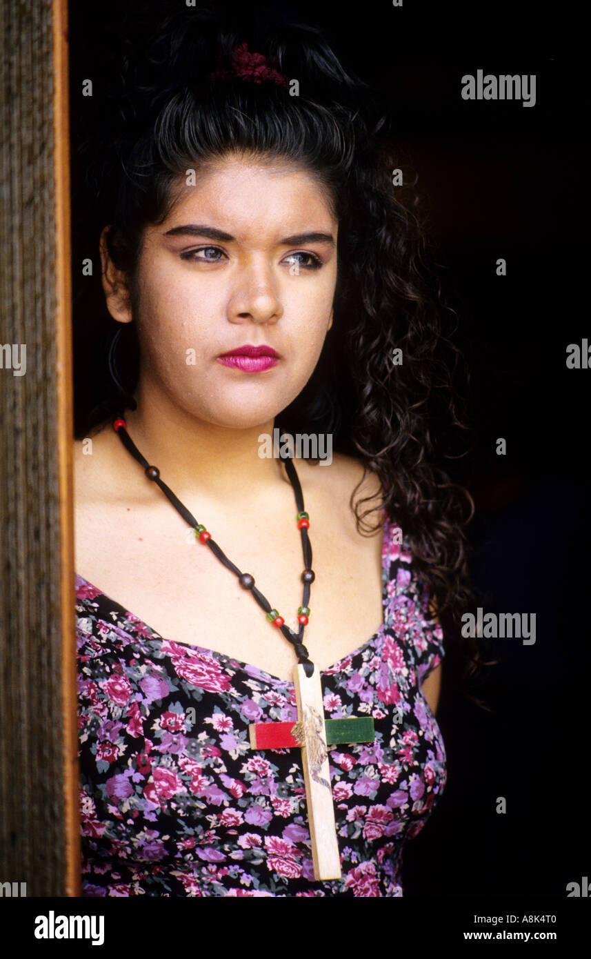 Giovane latina donna che indossa in casa croce di legno con colori messicani in un rally UFW, California. 1994 Foto Stock