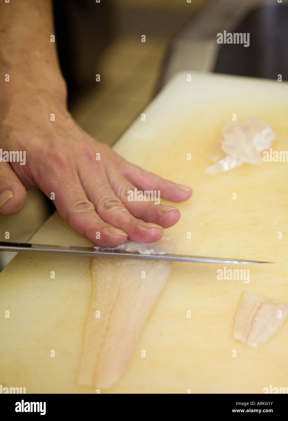Affettare la passera di mare per il sashimi in un ristorante giapponese Foto Stock